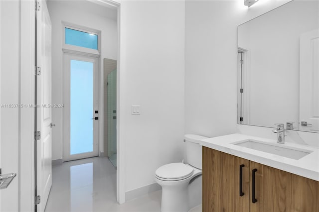 bathroom featuring vanity, toilet, and a shower with door