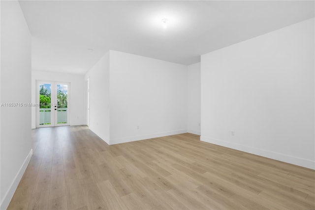 spare room featuring light wood-type flooring and french doors