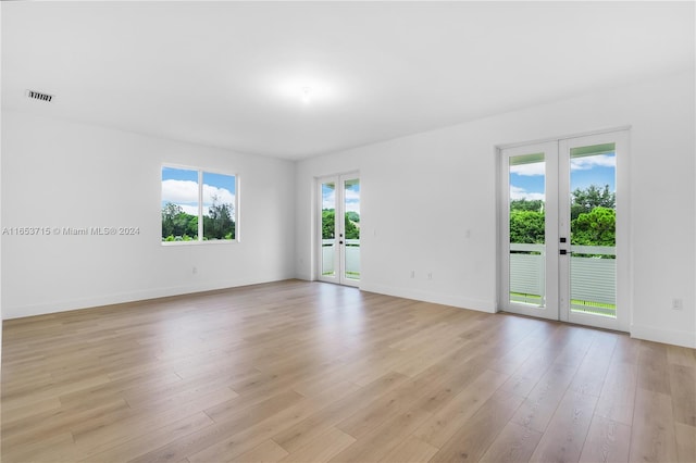 unfurnished room with french doors and light hardwood / wood-style floors