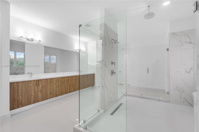 bathroom featuring a shower with shower door and vanity