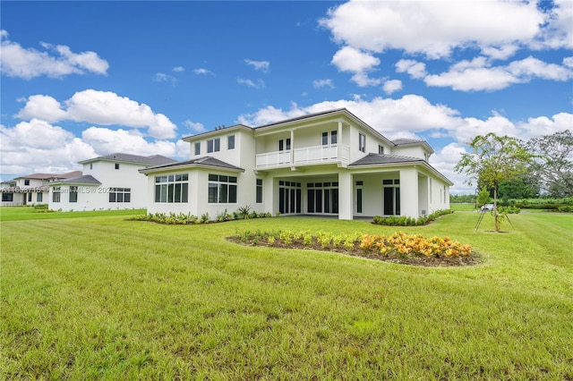 back of property featuring a lawn and a balcony