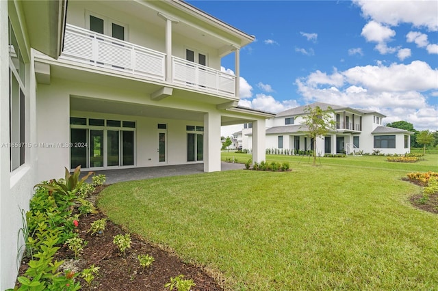 view of yard with a balcony and a patio area