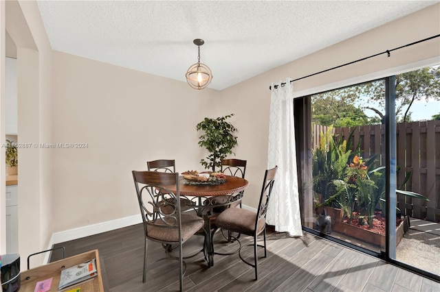 dining room featuring a textured ceiling and dark hardwood / wood-style flooring