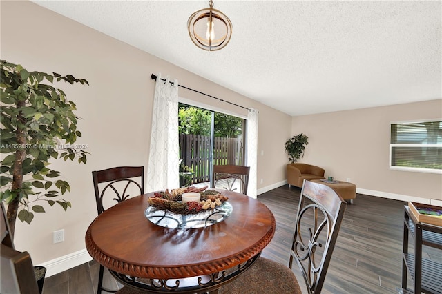 dining space featuring a textured ceiling and dark hardwood / wood-style flooring