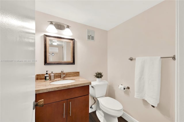 bathroom featuring wood-type flooring, vanity, and toilet