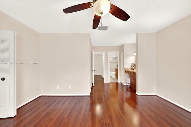 empty room with a textured ceiling, dark hardwood / wood-style floors, and ceiling fan