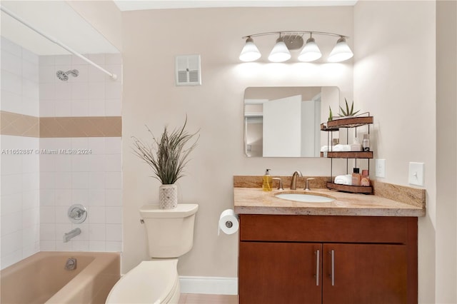 full bathroom with tile patterned flooring, tiled shower / bath, vanity, and toilet