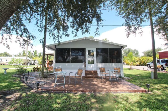 1113 Lissie Ln, Bulkhead Ridge, FL 34974 - rear view of property featuring a sunroom and a lawn