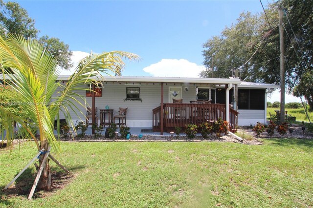 1113 Lissie Ln, Bulkhead Ridge, FL 34974 - rear view of property with a sunroom and a yard