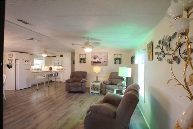 1113 Lissie Ln, Bulkhead Ridge, FL 34974 - living area featuring visible vents, wood finished floors, and a ceiling fan