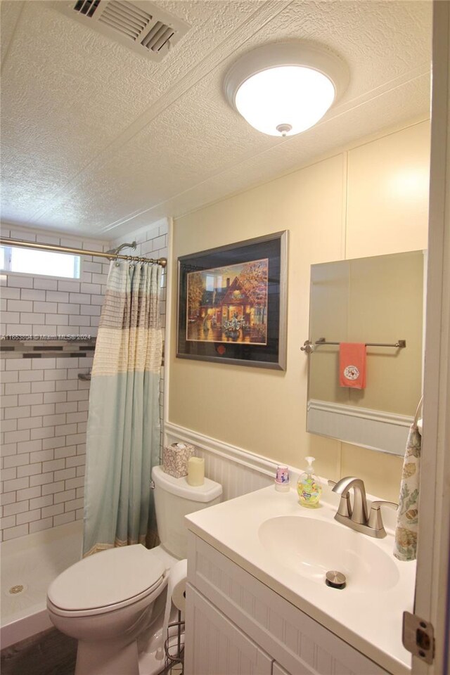 1113 Lissie Ln, Bulkhead Ridge, FL 34974 - full bath featuring a textured ceiling, visible vents, toilet, a stall shower, and wainscoting