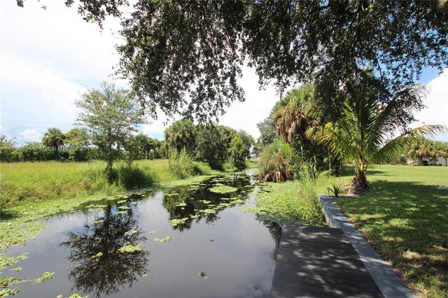 1113 Lissie Ln, Bulkhead Ridge, FL 34974 - view of property's community with a lawn and a water view
