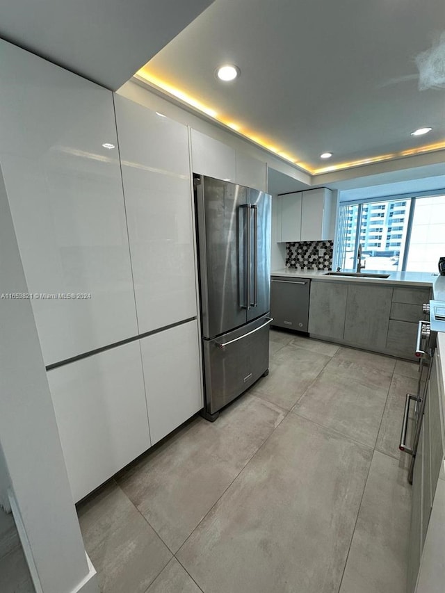 kitchen featuring white cabinets, stainless steel appliances, sink, and decorative backsplash