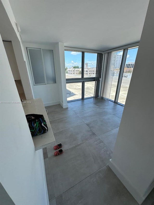 hallway with floor to ceiling windows and concrete flooring