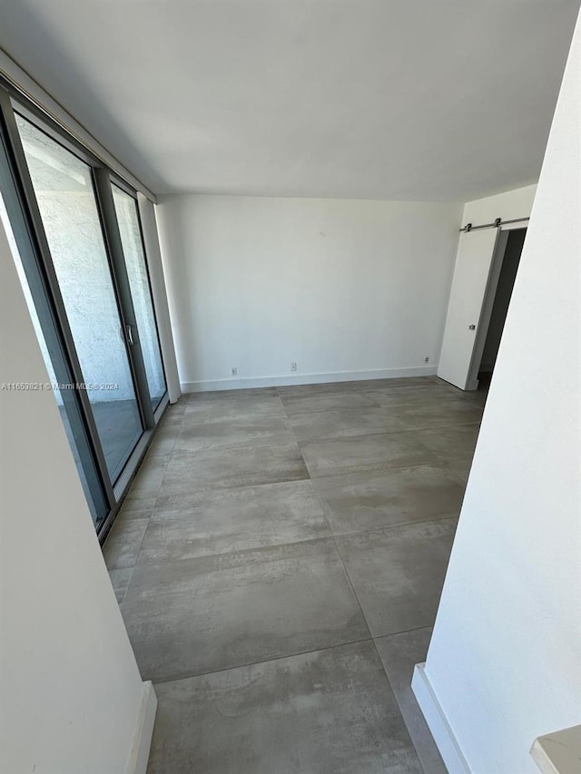 unfurnished room featuring a barn door and concrete floors