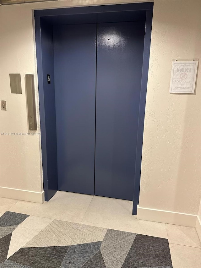 details with elevator and tile patterned floors