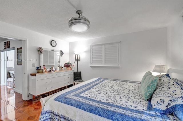 bedroom featuring parquet flooring and a textured ceiling