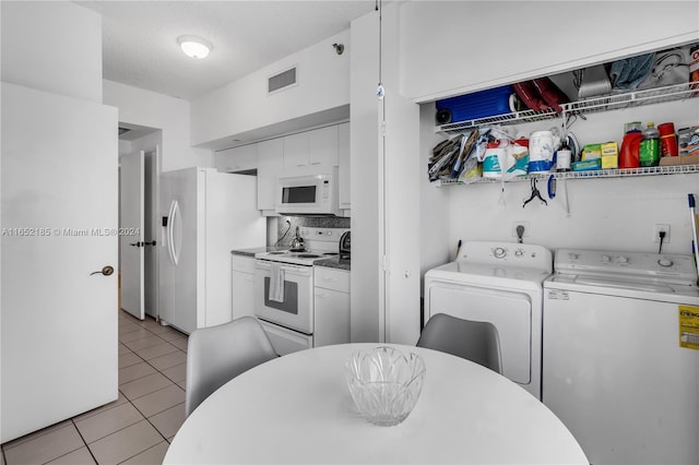 interior space featuring separate washer and dryer, white cabinets, a textured ceiling, white appliances, and light tile patterned floors