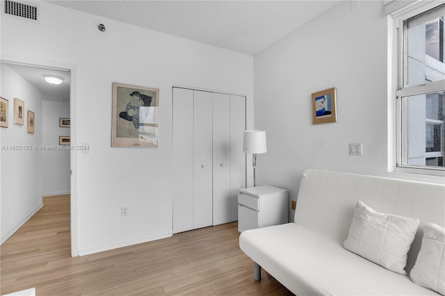 sitting room featuring light hardwood / wood-style flooring and a textured ceiling