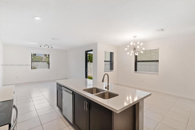 kitchen featuring light tile patterned floors, sink, decorative light fixtures, a center island with sink, and stainless steel appliances