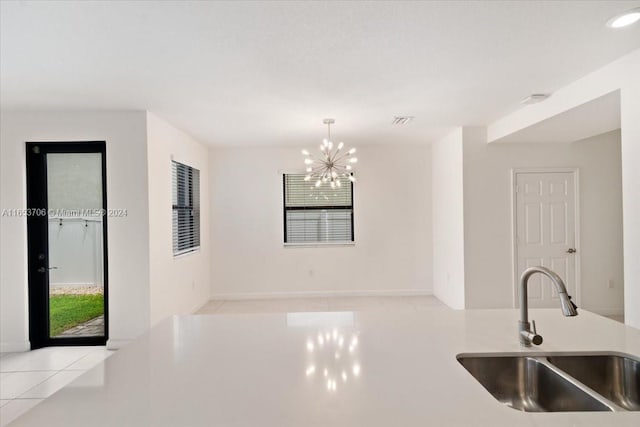 kitchen featuring light tile patterned flooring, decorative light fixtures, sink, and a chandelier