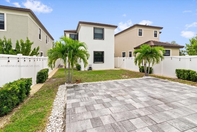 rear view of property with a patio and a lawn