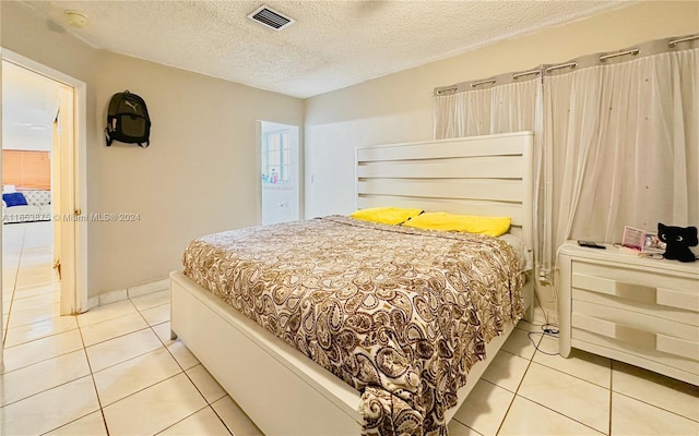 bedroom featuring light tile patterned floors and a textured ceiling