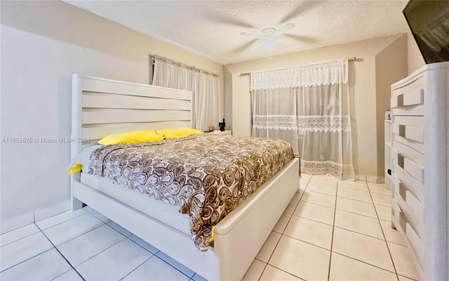 tiled bedroom featuring a textured ceiling and ceiling fan