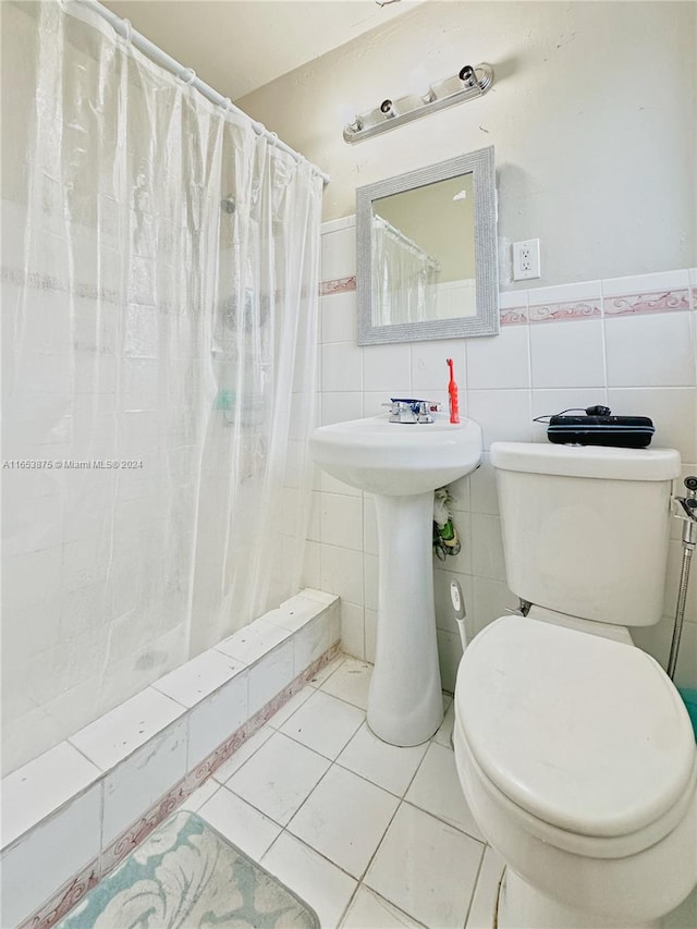 bathroom featuring toilet, tile patterned floors, tasteful backsplash, tile walls, and a shower with curtain