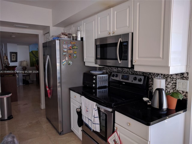 21055 Yacht Club Dr Unit 1602, Aventura, FL 33180 - kitchen featuring dark countertops, light tile patterned floors, stainless steel appliances, backsplash, and white cabinetry