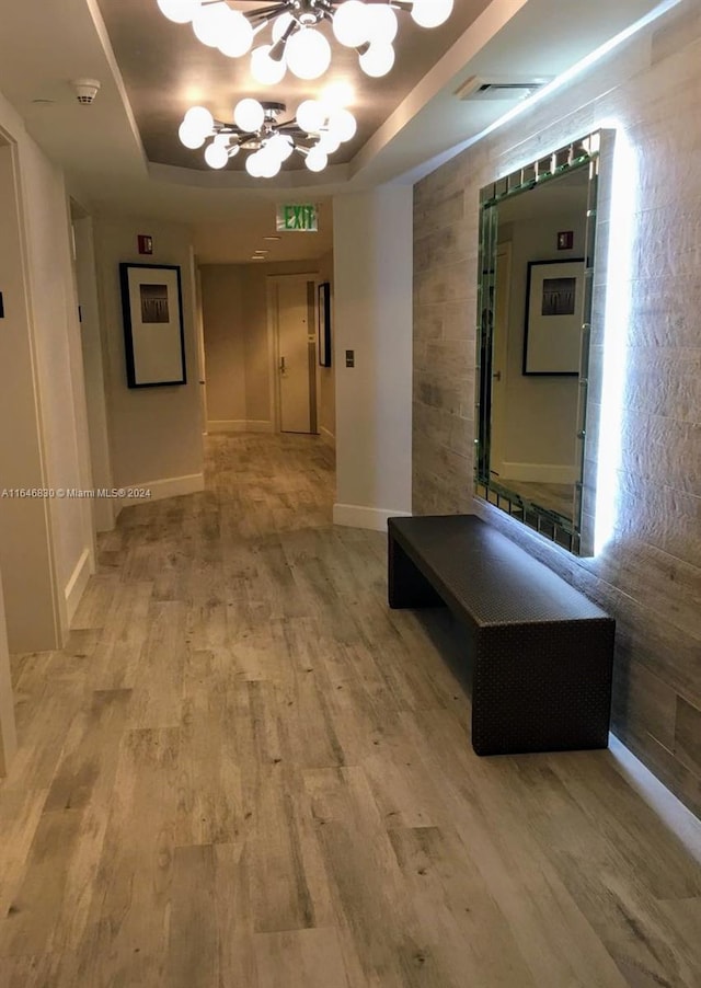 21055 Yacht Club Dr Unit 1602, Aventura, FL 33180 - hallway featuring an inviting chandelier, a tray ceiling, visible vents, light wood-type flooring, and baseboards