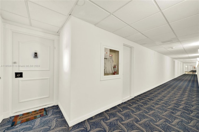 interior space with dark carpet and a paneled ceiling