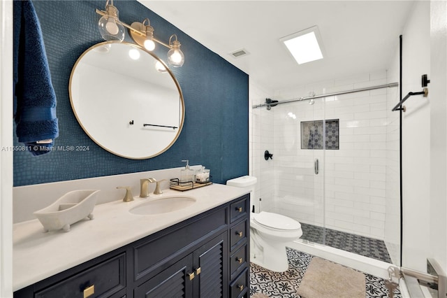 bathroom featuring tile patterned flooring, vanity, toilet, and a shower with shower door