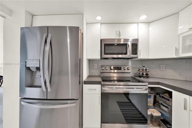 kitchen featuring appliances with stainless steel finishes, white cabinets, and decorative backsplash