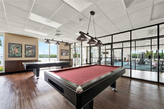 game room featuring floor to ceiling windows, pool table, dark hardwood / wood-style flooring, and a drop ceiling