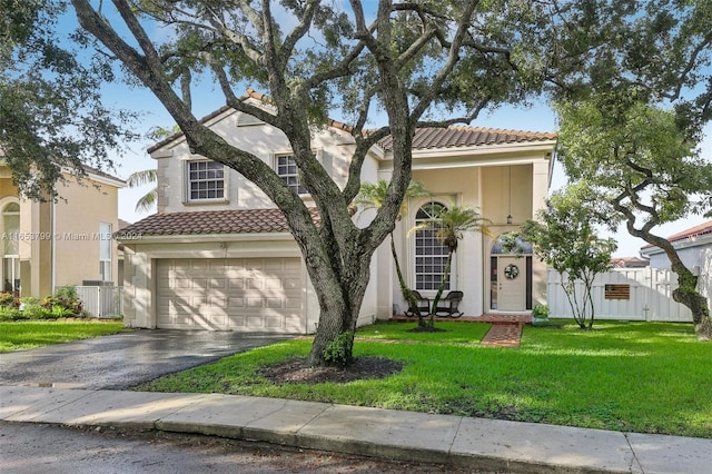 mediterranean / spanish-style house with a garage, central AC unit, and a front yard