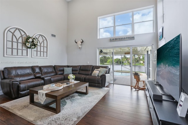 living room with dark wood-type flooring and a high ceiling