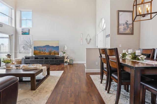 dining space featuring a high ceiling, dark hardwood / wood-style floors, and a chandelier