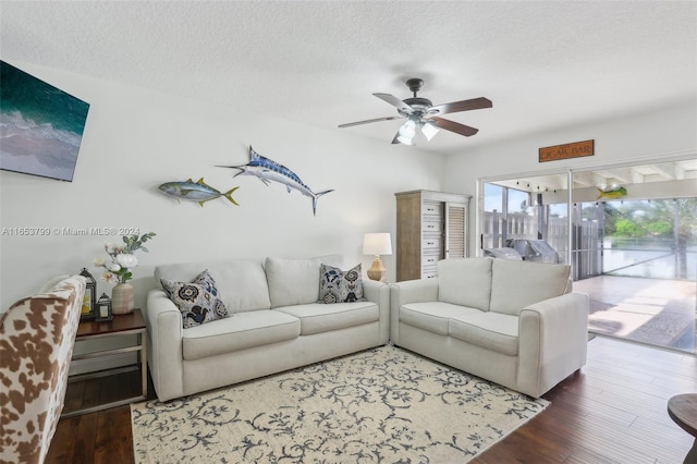 living room with ceiling fan, wood-type flooring, and a textured ceiling