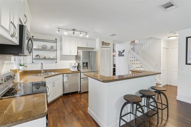 kitchen featuring appliances with stainless steel finishes, white cabinetry, sink, and dark wood-type flooring