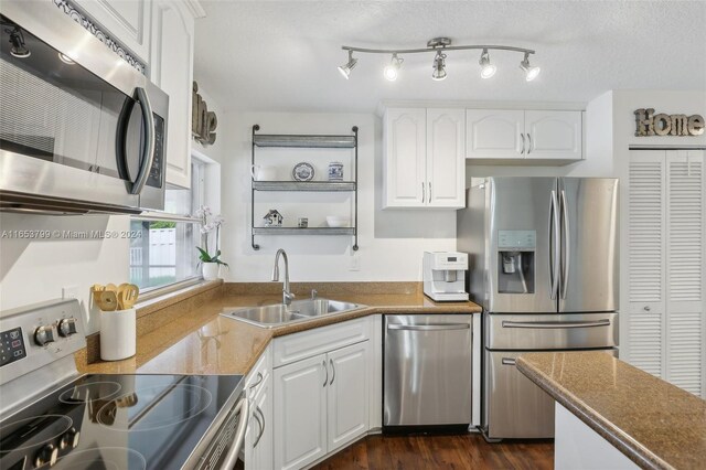 kitchen featuring white cabinets, stainless steel appliances, dark hardwood / wood-style flooring, sink, and a textured ceiling