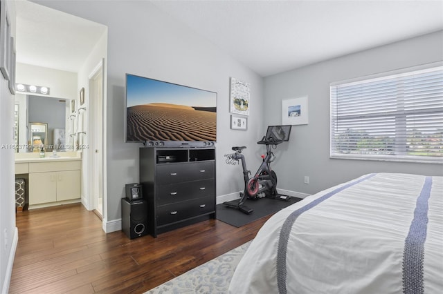 bedroom featuring dark hardwood / wood-style floors, connected bathroom, and vaulted ceiling