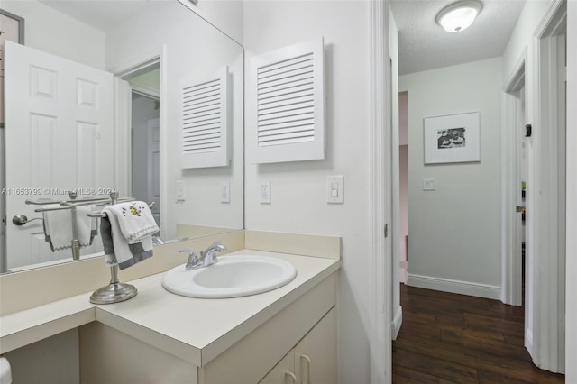 bathroom featuring a textured ceiling, vanity, and hardwood / wood-style flooring