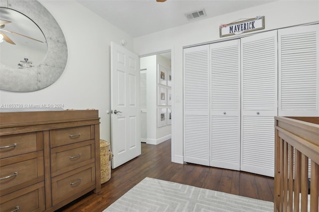 bedroom featuring dark wood-type flooring, a closet, and ceiling fan