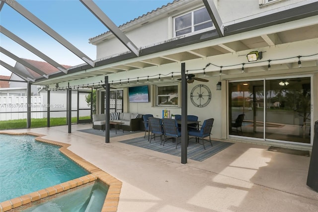 rear view of house with a patio area, glass enclosure, and a swimming pool with hot tub