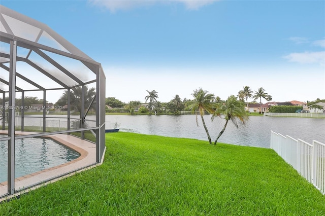 view of yard featuring glass enclosure and a water view