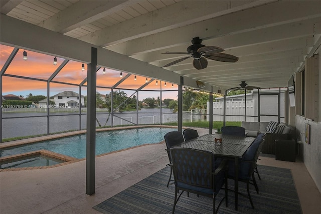 pool at dusk with a water view, ceiling fan, a lanai, and a patio