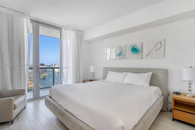 bedroom featuring expansive windows and access to exterior