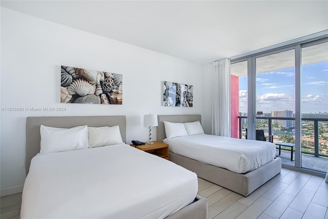 bedroom featuring floor to ceiling windows, access to exterior, and light hardwood / wood-style floors