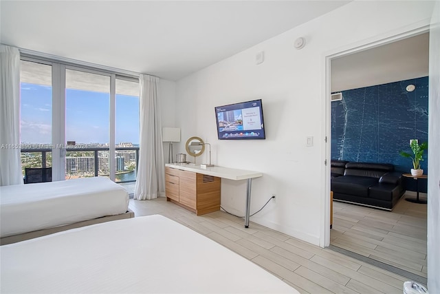 bedroom featuring light wood-type flooring and floor to ceiling windows